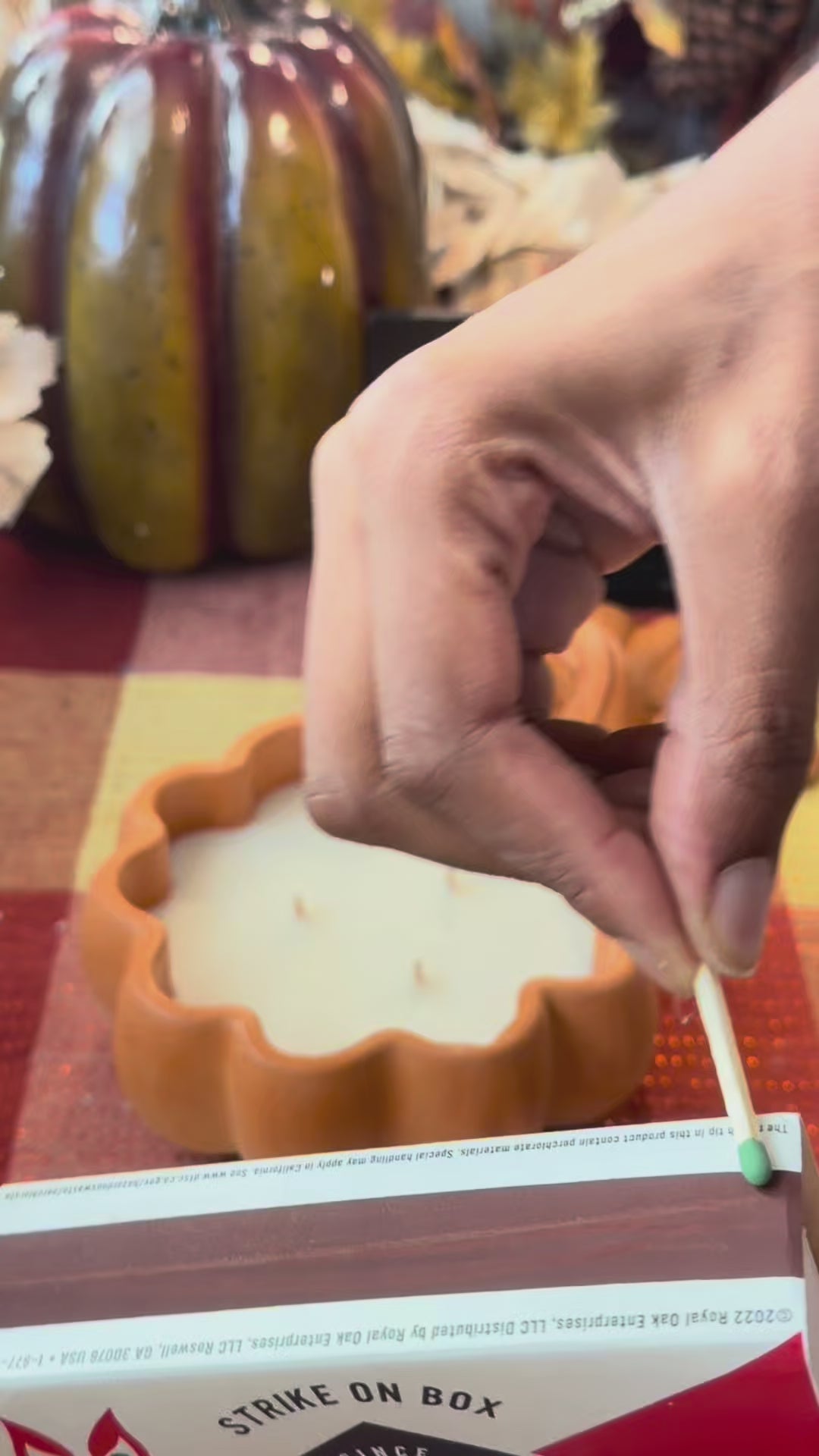 Lighting a handmade concrete pumpkin candle in rustic orange by Aura Aligned Creations